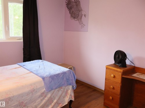 Room featuring a single casement window, light purple walls, and wood-finish flooring - 58403 Rr 60, Rural Barrhead County, AB - Indoor Photo Showing Bedroom