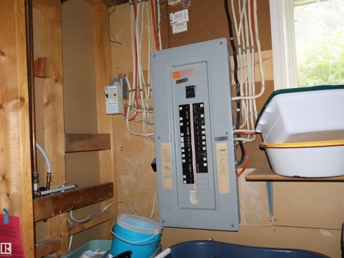 Electrical service panel mounted on a wall with exposed wiring - 58403 Rr 60, Rural Barrhead County, AB - Indoor Photo Showing Basement