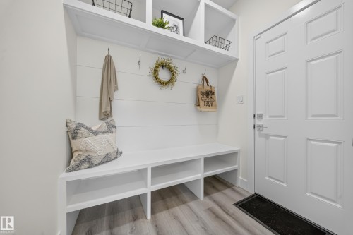 Built-in entryway bench with integrated storage cubbies, shiplap-style wall paneling, and overhead shelving - 1099 Eaton Road, Edmonton, AB 