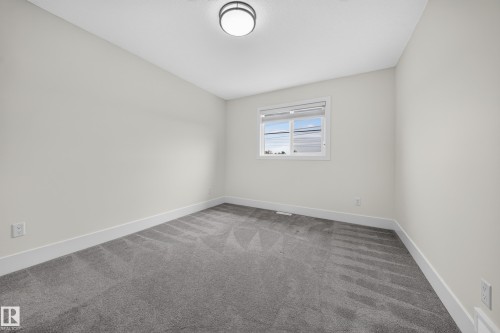 Neutral-toned interior room with gray carpet flooring - 1099 Eaton Road, Edmonton, AB 