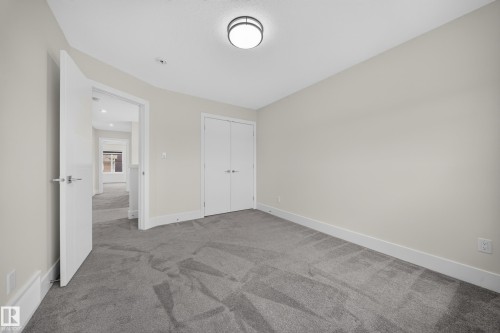 Neutral tone walls with white trim, gray carpet flooring, and a flush mount ceiling light - 1099 Eaton Road, Edmonton, AB 