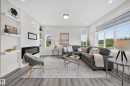 Living area featuring wood-finish flooring and multiple windows - 1099 Eaton Road, Edmonton, AB 