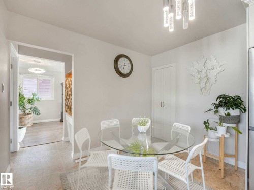 Dining area featuring a contemporary ceiling light fixture, neutral wall paint, and a built-in double-door cabinet - 9207 169 Street, Edmonton, AB - Indoor Photo Showing Dining Room