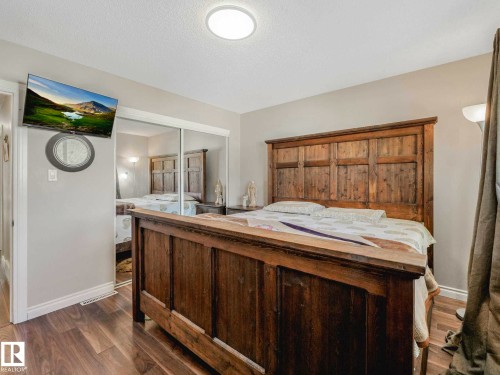 Wood-finish flooring throughout, complemented by light-toned wall paint and white trim - 9207 169 Street, Edmonton, AB - Indoor Photo Showing Bedroom