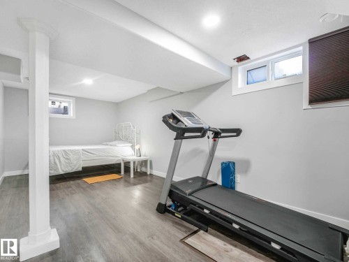Finished lower level featuring recessed lighting, light gray walls, wood-finish flooring, white trim, and a window for natural light - 9207 169 Street, Edmonton, AB - Indoor Photo Showing Gym Room