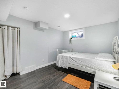 Spacious room featuring light gray walls, recessed lighting, wood-finish flooring, and a white-trimmed window - 9207 169 Street, Edmonton, AB - Indoor Photo Showing Bedroom
