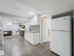 Open concept living area with light wood-finish flooring - 