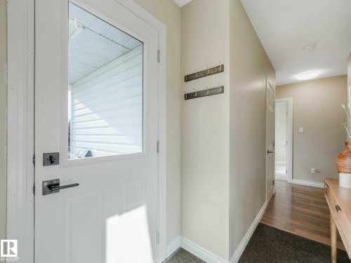 Entryway featuring a white door with a clear glass insert, contemporary brushed nickel hardware, and wood-finish flooring - 9207 169 Street, Edmonton, AB - Indoor Photo Showing Other Room