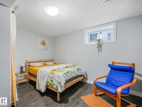 Bedroom featuring wood-finish flooring, a contemporary window, recessed ceiling light, and a surface-mounted ceiling light - 9207 169 Street, Edmonton, AB - Indoor Photo Showing Bedroom