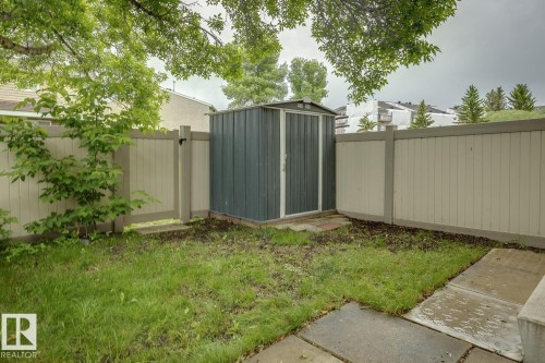Backyard space featuring a storage shed, concrete patio pavers, and a privacy fence - 1131 Hooke Road, Edmonton, AB 
