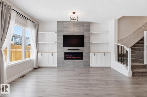 Living area featuring light wood-finish flooring and a large window - 3234 Chernowski Way, Edmonton, AB 
