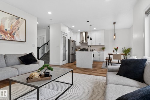 Open-concept living space featuring wood-finish flooring and recessed lighting - 9628 221 Street, Edmonton, AB 