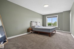 Bedroom featuring plush gray carpeting, neutral green walls, and white trim - 