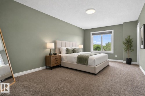 Spacious room featuring muted green walls and light brown carpeting - 9628 221 Street, Edmonton, AB 