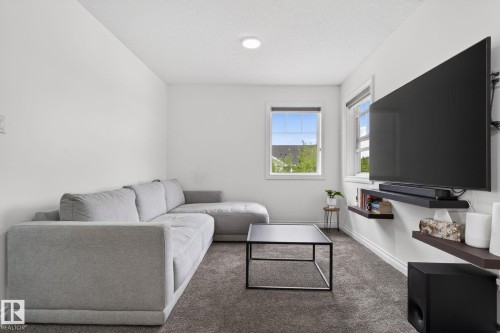 Carpeted media room featuring white walls, recessed ceiling lighting, and two windows - 9628 221 Street, Edmonton, AB 