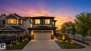 Contemporary two-story residence featuring a two-car garage, stone veneer accents, integrated outdoor lighting, and a paved driveway - 9628 221 Street, Edmonton, AB 