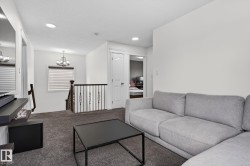 Spacious upper-level area featuring dark gray carpeting and recessed lighting - 