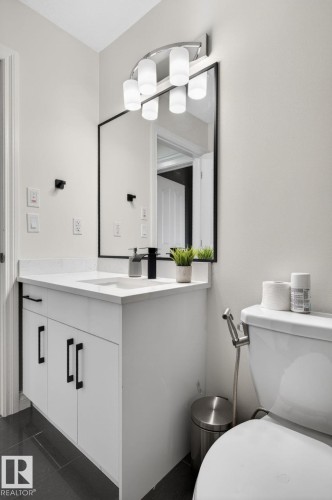 White vanity with a rectangular undermount sink, a quartz countertop, and matte black faucet - 9628 221 Street, Edmonton, AB 