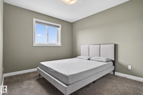 Bedroom featuring a window with white trim, light gray walls, white baseboards, and carpet flooring - 9628 221 Street, Edmonton, AB 