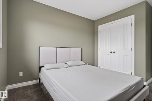 Carpeted room featuring a white bi-fold closet, neutral wall paint, and white trim - 9628 221 Street, Edmonton, AB 