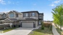 Contemporary two-story residence featuring a two-tone exterior with stone accents and a prominent attached garage - 9628 221 Street, Edmonton, AB 