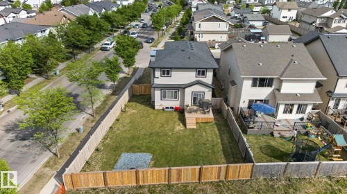 Rear exterior featuring a spacious fenced yard, wood deck, and light-colored siding - 9628 221 Street, Edmonton, AB 