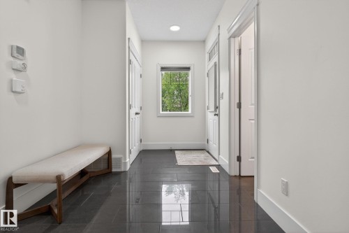 Entryway featuring dark tile flooring, white baseboards, and a window with natural light - 9628 221 Street, Edmonton, AB 