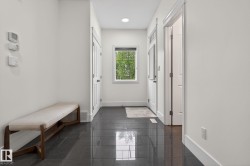 Entryway featuring dark tile flooring, white baseboards, and a window with natural light - 