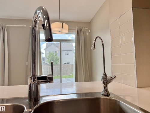Stainless steel double basin sink with a contemporary chrome gooseneck faucet featuring a single lever handle and an additional chrome filtration faucet - 22519 96 Avenue, Edmonton, AB 