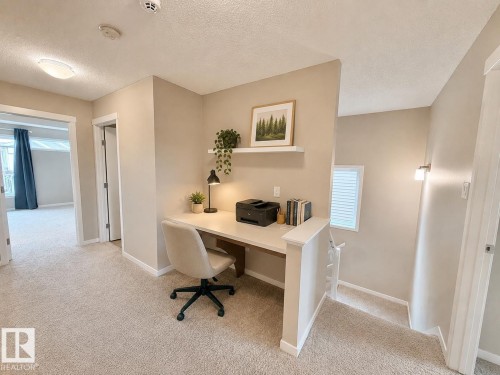 Built-in desk with a floating shelf, recessed lighting, and wall-mounted sconces - 22519 96 Avenue, Edmonton, AB 