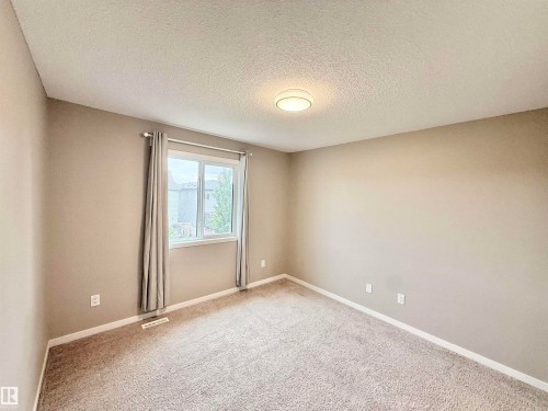 Bedroom featuring neutral wall paint, light-toned carpet, and a window with drapes - 22519 96 Avenue, Edmonton, AB 
