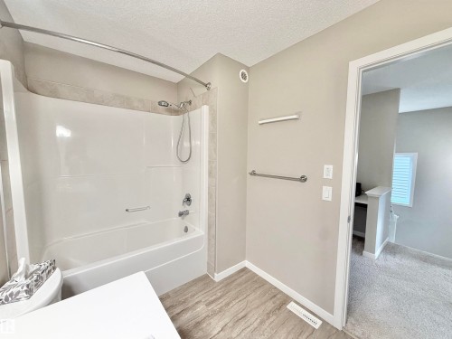 White acrylic tub and shower combination with a curved shower rod - 22519 96 Avenue, Edmonton, AB 