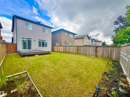 Expansive backyard featuring a manicured lawn, a wood deck, wood privacy fencing, and garden beds - 22519 96 Avenue, Edmonton, AB 