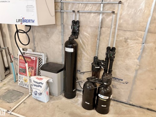 Comprehensive water filtration system with multiple tanks and associated plumbing, complemented by a suspended ventilation unit - 22519 96 Avenue, Edmonton, AB 