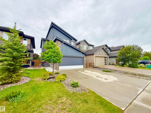 Contemporary two-story exterior featuring blue vertical siding and stone accents - 22519 96 Avenue, Edmonton, AB 