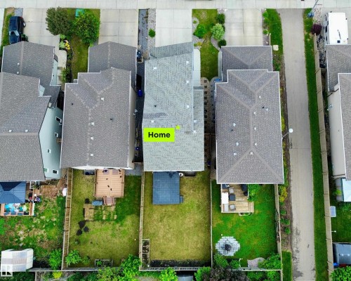 Aerial perspective of a property featuring a gray shingle roof, a backyard with a wood deck, a patch of green lawn, and a small outbuilding - 22519 96 Avenue, Edmonton, AB 
