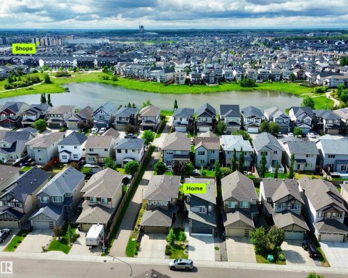 Aerial view of a residential neighborhood featuring a central pond and green spaces - 22519 96 Avenue, Edmonton, AB 