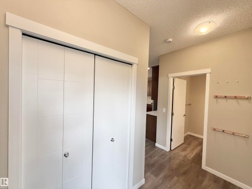 White bi-fold closet doors with panel detailing, wood-finish flooring, and neutral wall tones - 22519 96 Avenue, Edmonton, AB 