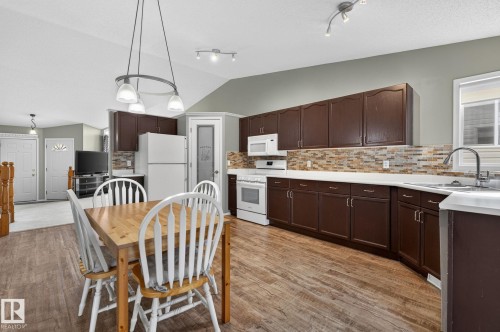 Open-concept kitchen and dining area featuring wood-finish flooring - 6225 159A Avenue, Edmonton, AB 
