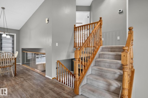 Carpeted staircase with natural wood railing and balusters - 6225 159A Avenue, Edmonton, AB 