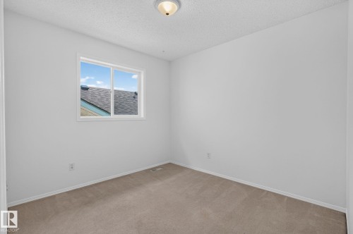 Neutral tone wall finishes, beige carpet flooring, and a single window with white trim - 6225 159A Avenue, Edmonton, AB 