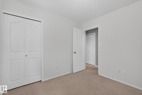 Neutral-toned room with light gray walls and beige carpeting - 6225 159A Avenue, Edmonton, AB 