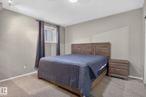 Carpeted room featuring a window with privacy glass, track lighting, and neutral wall tones - 6225 159A Avenue, Edmonton, AB 