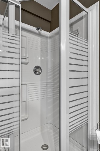 Corner shower enclosure with clear and frosted glass panels, an integrated showerhead, and a single-handle faucet - 6225 159A Avenue, Edmonton, AB 