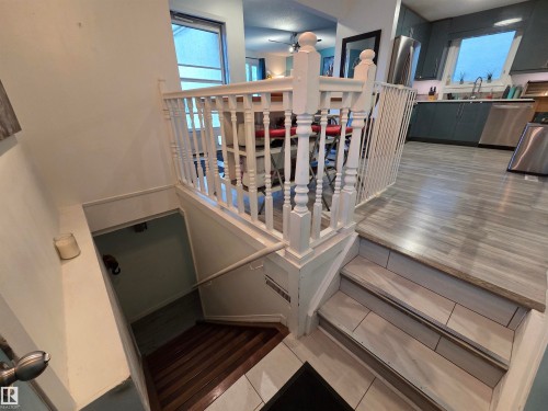White painted baluster railing system with wood-finish flooring on the main level - 2514 149 Avenue, Edmonton, AB 