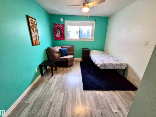 Room with wood-finish flooring, a ceiling fan with integrated lighting, and a window providing natural illumination - 2514 149 Avenue Nw, Edmonton, AB - Indoor Photo Showing Bedroom