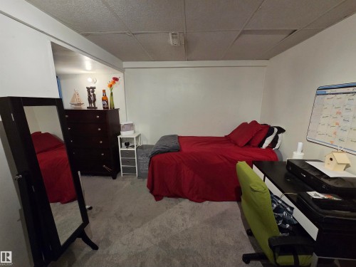 Carpeted room featuring a drop ceiling, white walls, and track lighting - 2514 149 Avenue, Edmonton, AB 