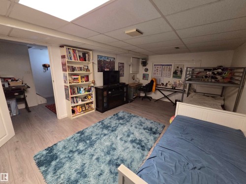 Finished basement space featuring light wood-finish flooring, white walls, and a drop ceiling with recessed lighting - 2514 149 Avenue, Edmonton, AB 