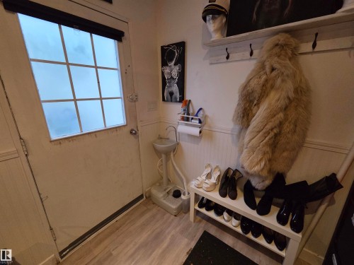 Entryway featuring a paneled door with nine-lite window, wood-finish flooring, and wainscoting - 2514 149 Avenue, Edmonton, AB 