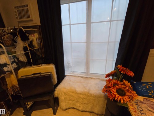 White-framed window with grid pattern, flanked by dark drapes, and a wall-mounted air conditioning unit - 2514 149 Avenue, Edmonton, AB 